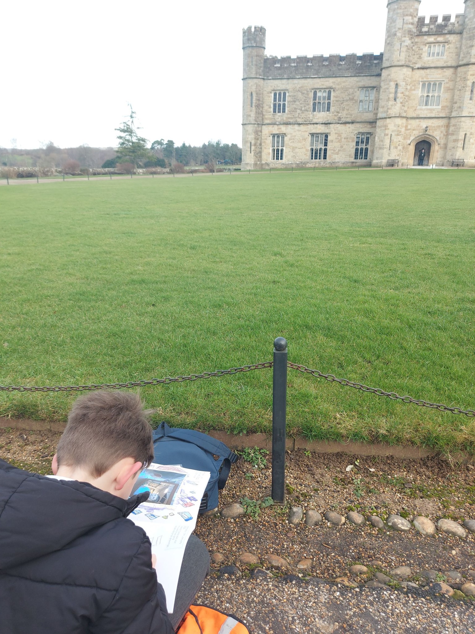 Students sat on the floor drawing, facing Leeds Castle