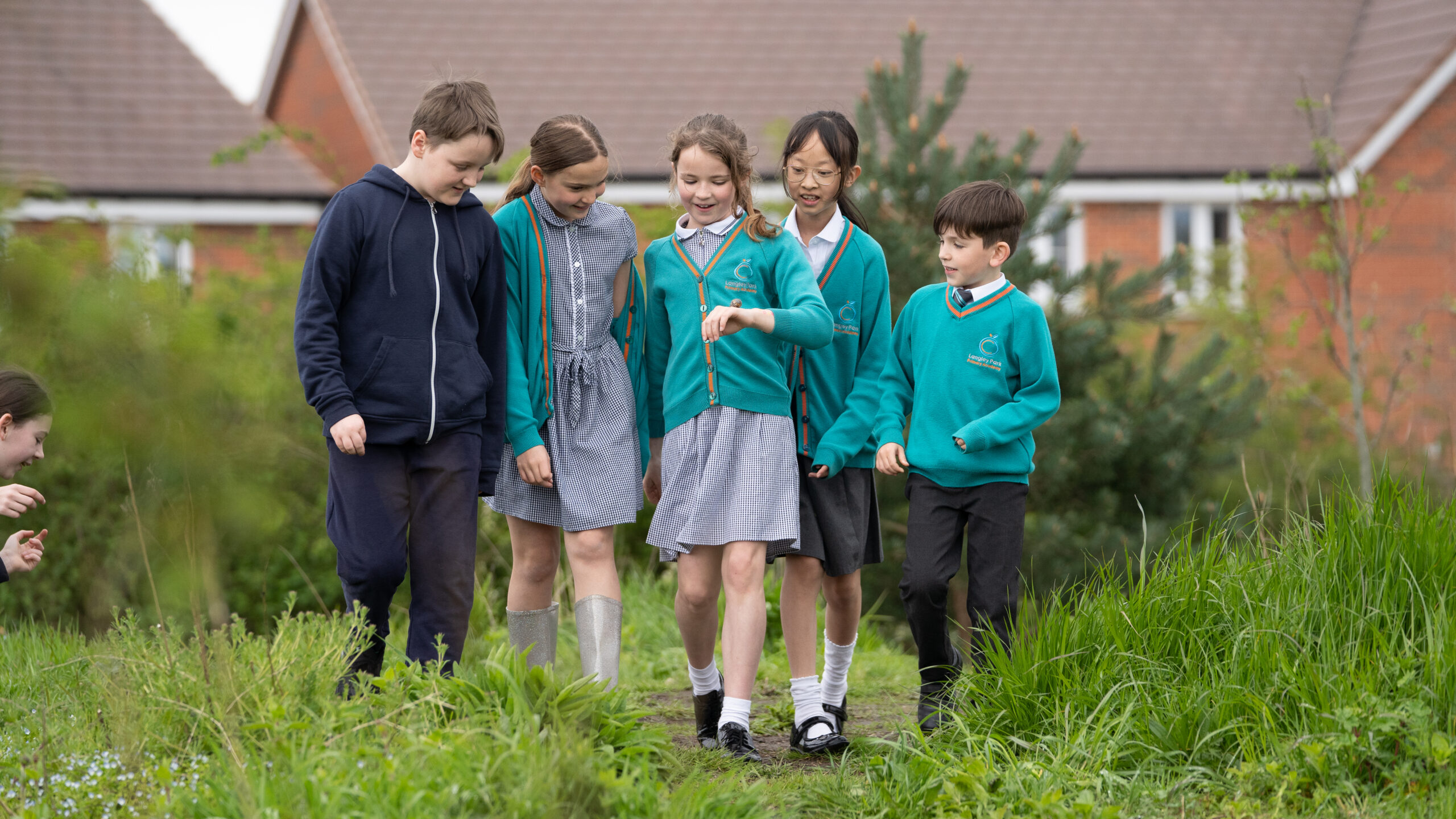 A group of children walking towards the camera smiling